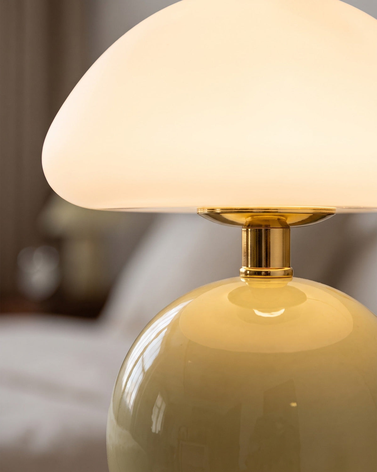 Close-up of the Dolce mushroom lamp's opal glass dome, brass-finish neck and cream base