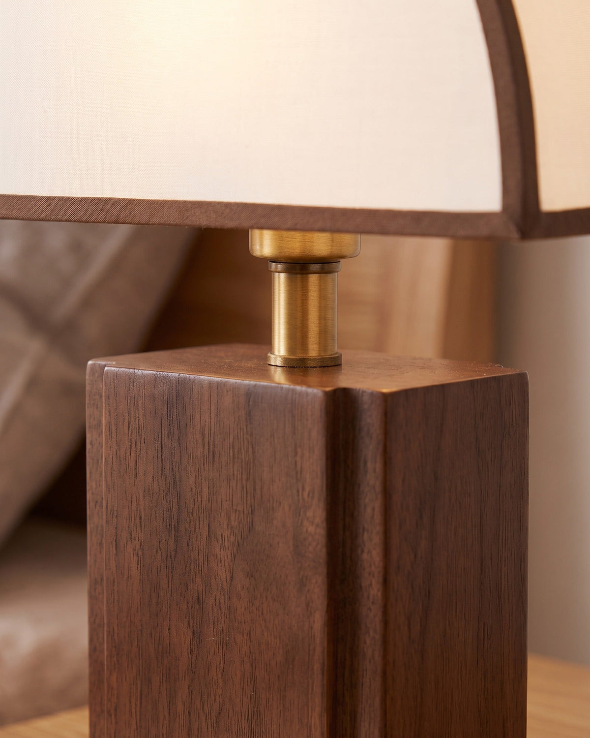 Close-up of the Halvo lamp's solid walnut block base and brass-finish fitting