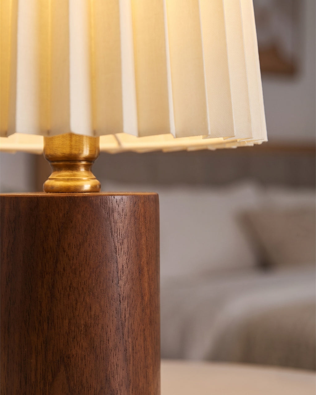 Walnut: Close-up of the Linnea lamp's walnut cylinder base and pleated fabric shade