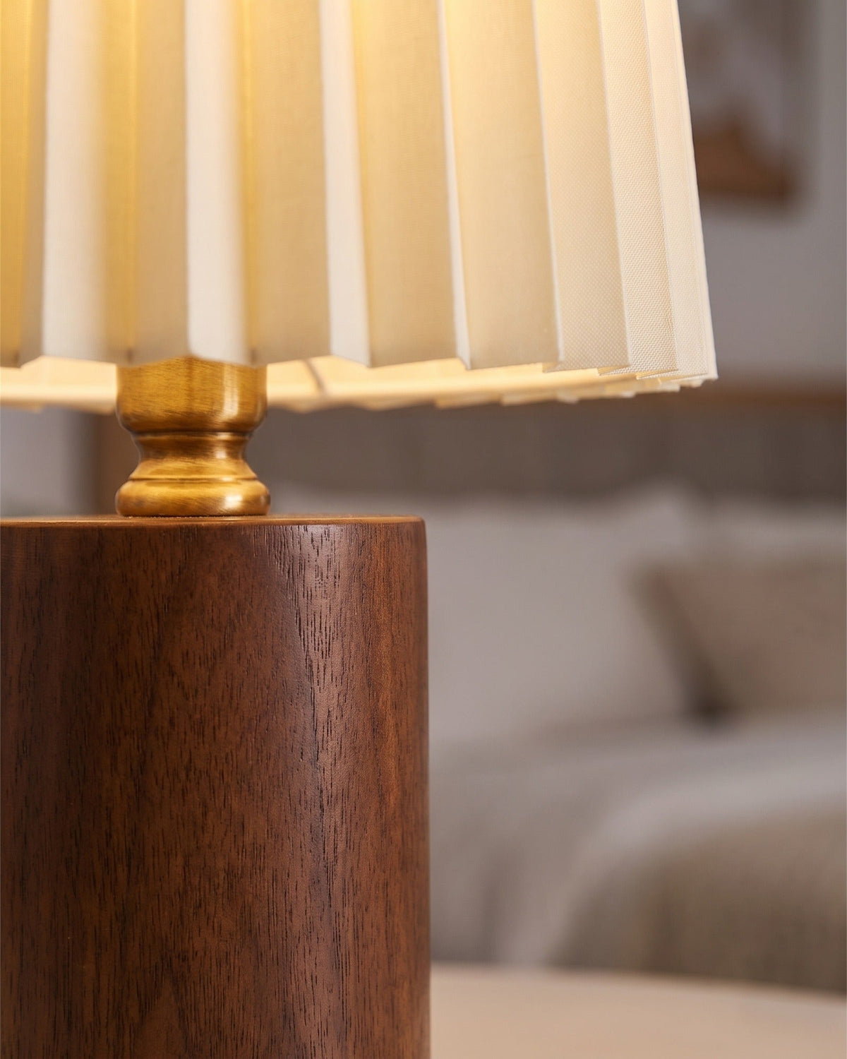 Close-up of the Linnea lamp's walnut cylinder base and pleated fabric shade