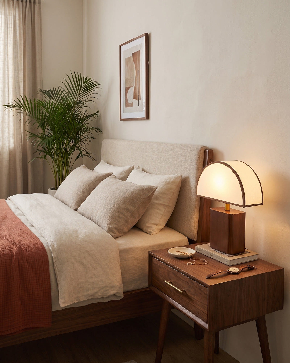Halvo half-dome walnut nightstand lamp in a warm bedroom, seen from the right