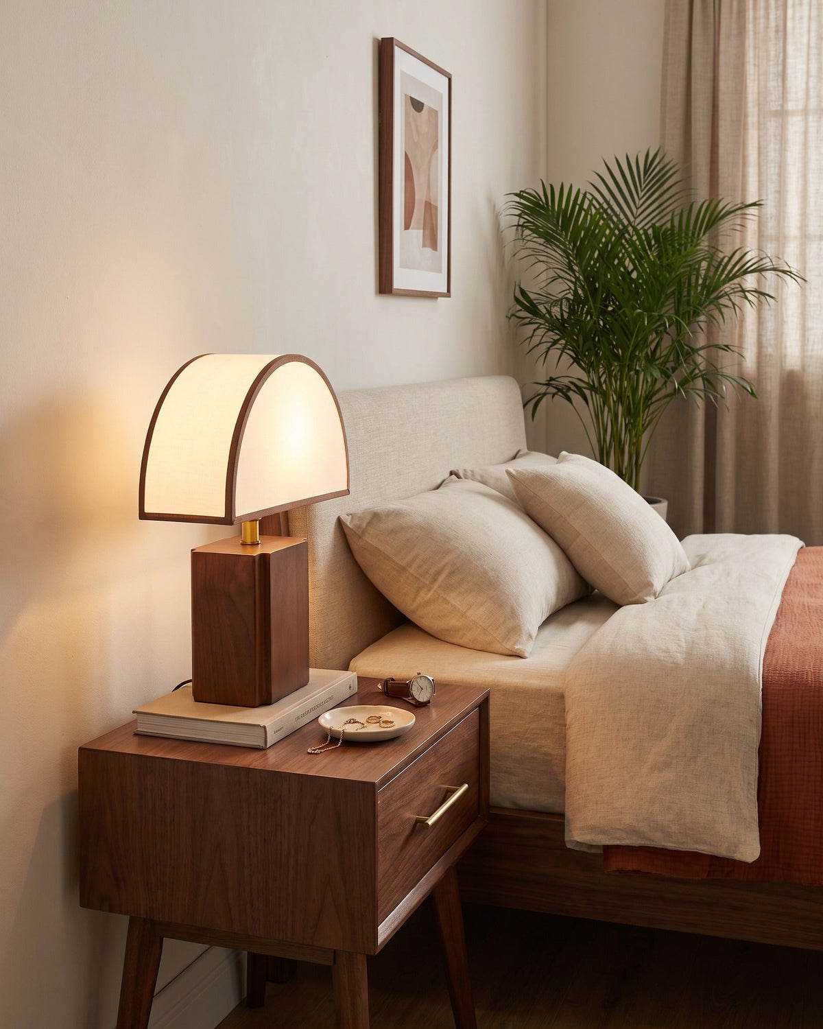 Halvo walnut lamp with a white half-dome shade on a nightstand, seen from the left