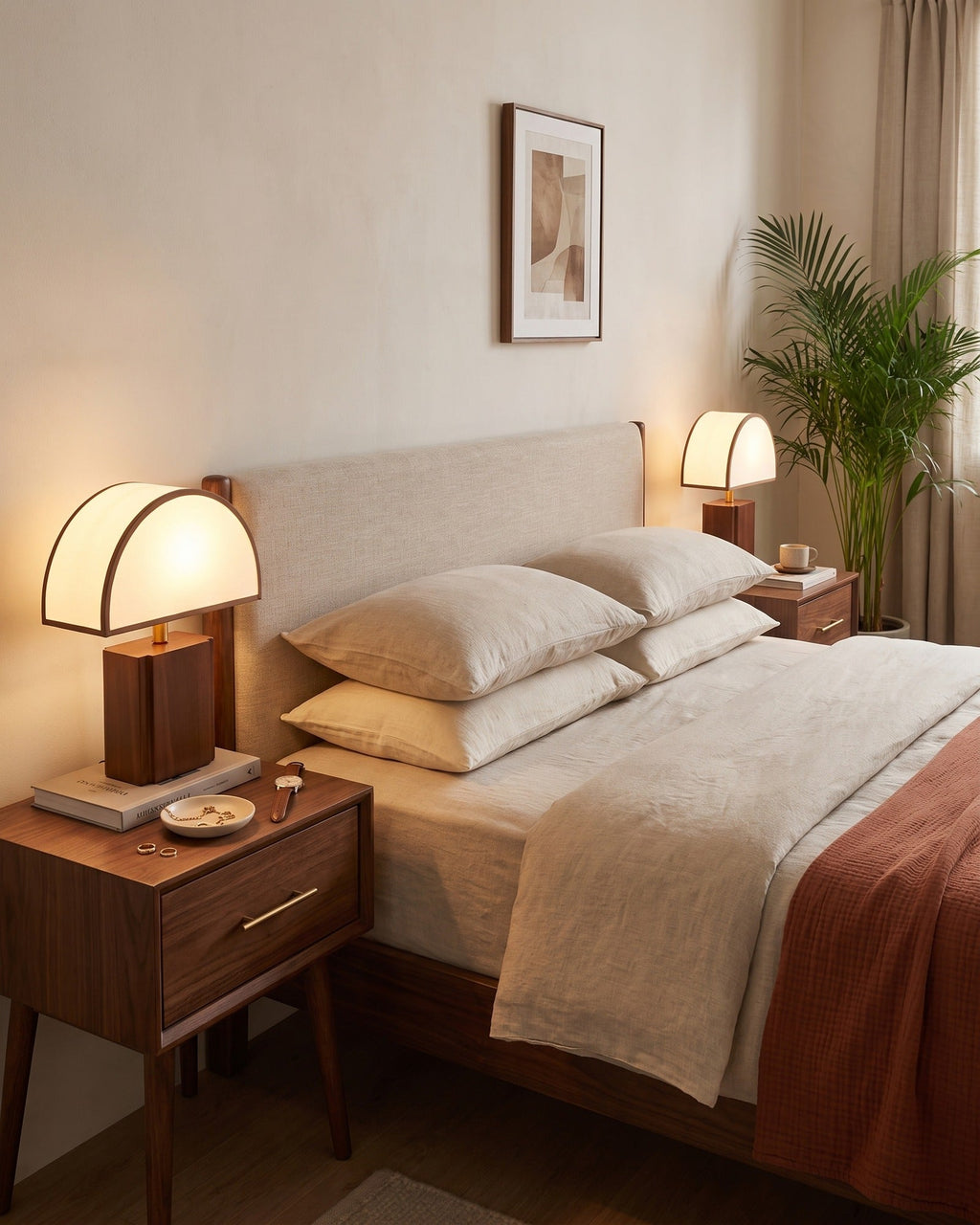 Halvo half-dome lamp on a walnut nightstand next to a bed with cream bedding