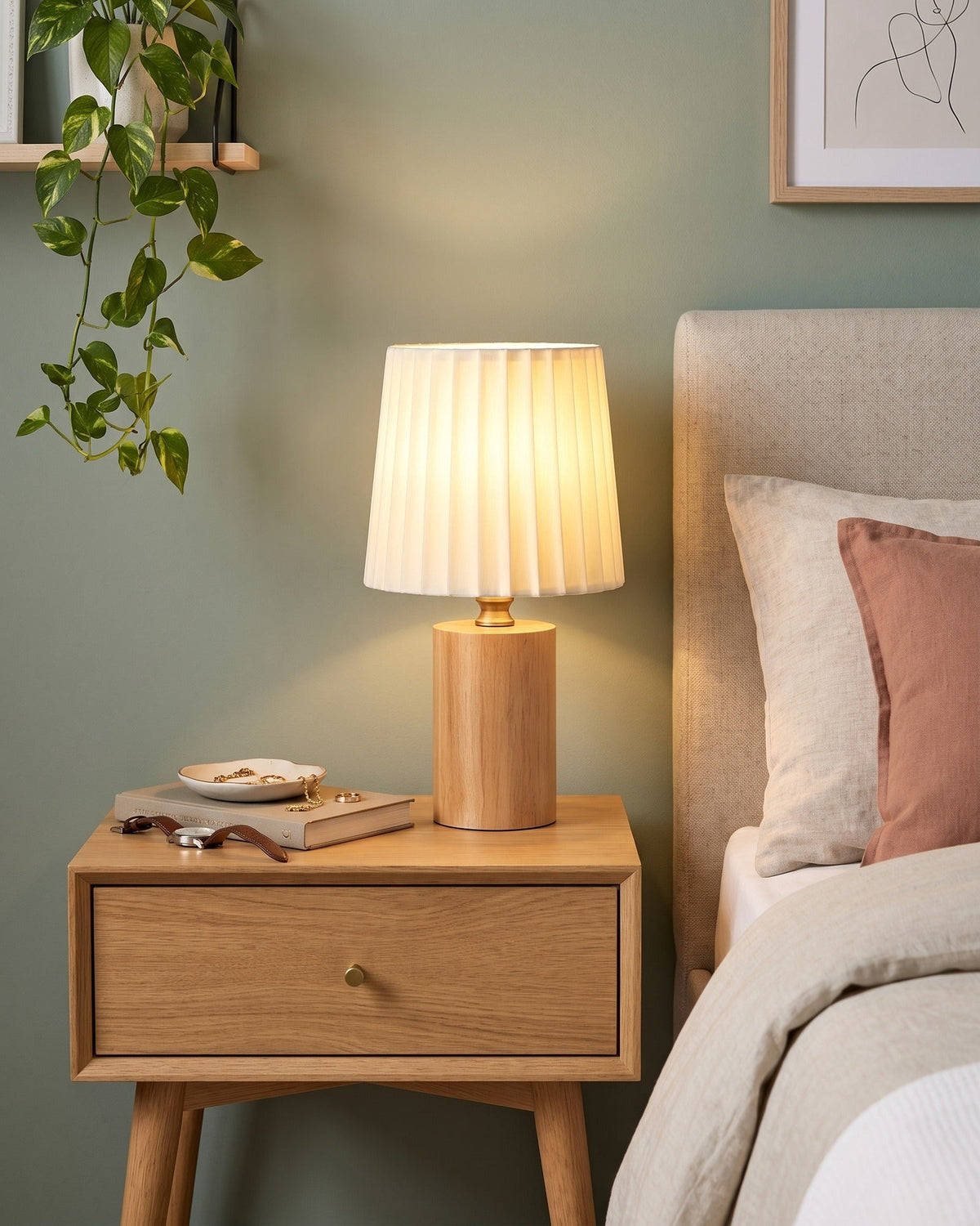 Linnea oak nightstand lamp with a pleated shade on an oak nightstand against a sage wall