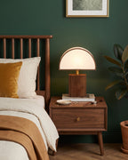 Halvo walnut nightstand lamp with a white half-dome shade against a dark green wall