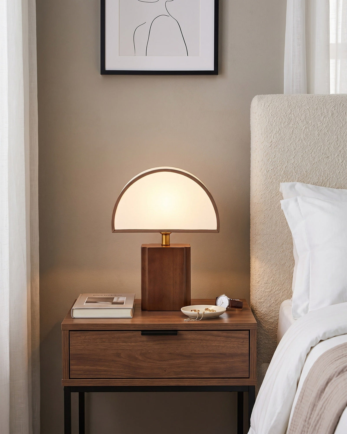 Halvo walnut half-dome lamp on a dark nightstand beside a greige upholstered bed