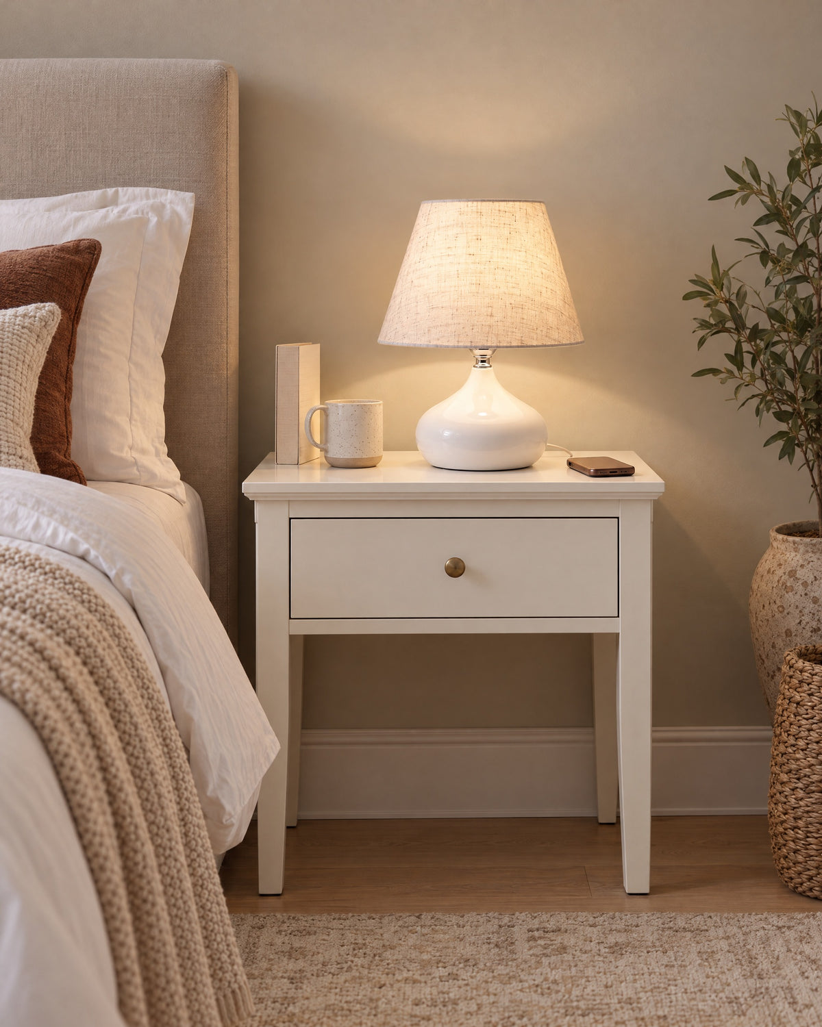 White: Aria Ceramic Nightstand Lamp in white on a standard nightstand, showing its true size
