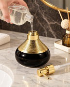 The Soap Dispenser, Ceramic, Black with Brushed Gold, 9 oz being refilled, pump set aside