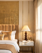 Bobbin Trio Wood Nightstand Lamp on a marble nightstand in a golden glam bedroom