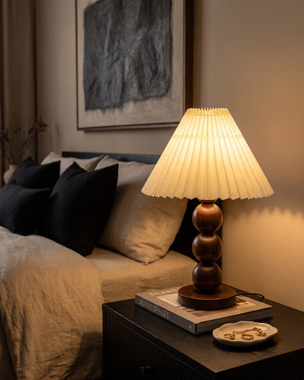 Bobbin Trio Wood Nightstand Lamp in a beige and black bedroom at night