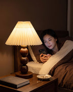 Walnut: Bobbin Trio Wood Nightstand Lamp glowing at night while reading in bed