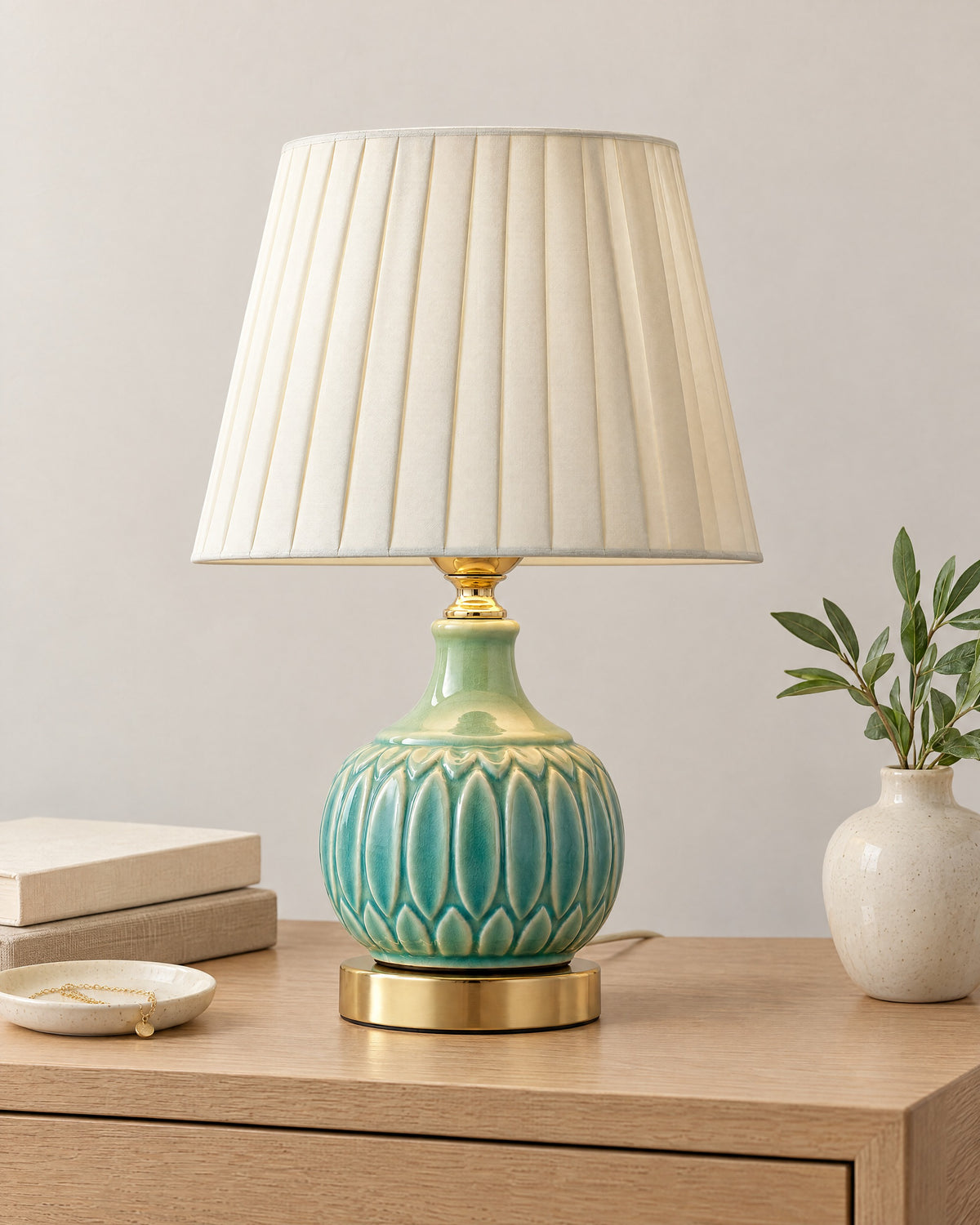 Celadon Carved Gourd Nightstand Lamp on a nightstand top against a light studio backdrop