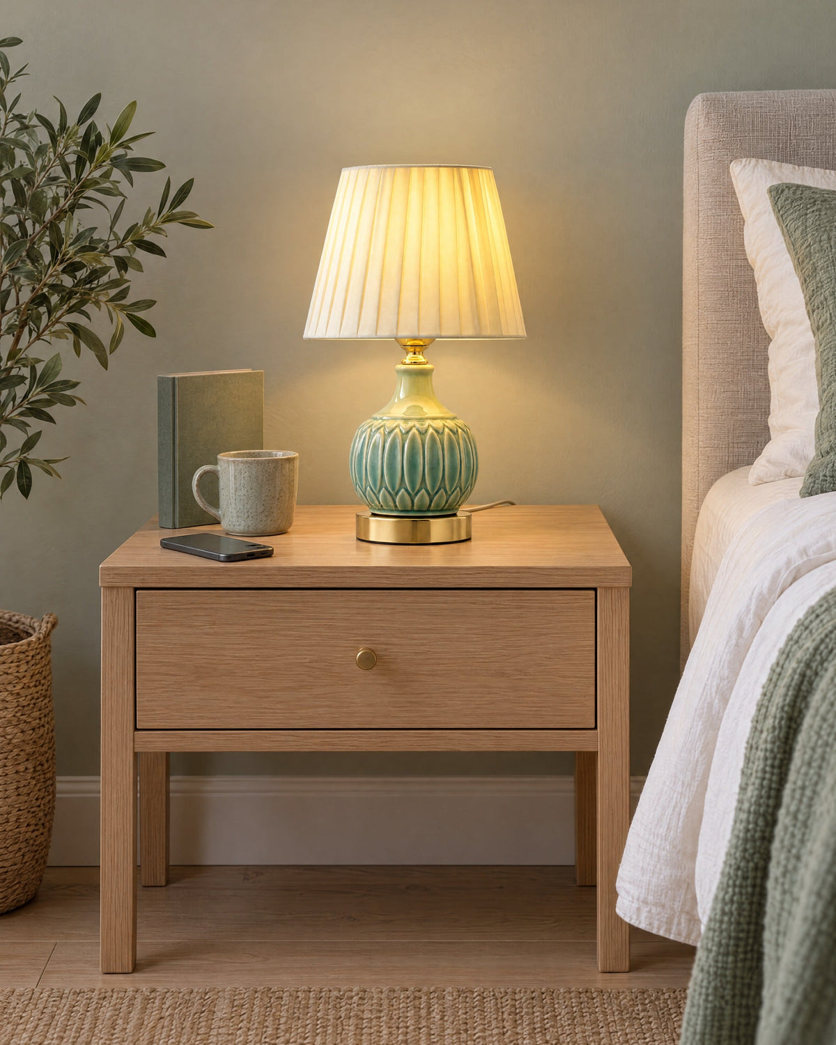 Celadon Carved Gourd Nightstand Lamp on a standard nightstand with a paperback, phone and mug for scale