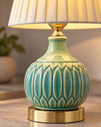 Close-up of the carved celadon crackle glaze and gold foot of the Celadon Carved Gourd Nightstand Lamp