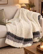 Chunky Knit Throw Blanket, Cream, Washable Feather Yarn on a sofa in warm evening light