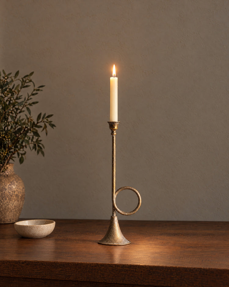 Tall (15.9 in): Corno Horn Ring Iron Candlestick, lit, on a styled surface in the evening