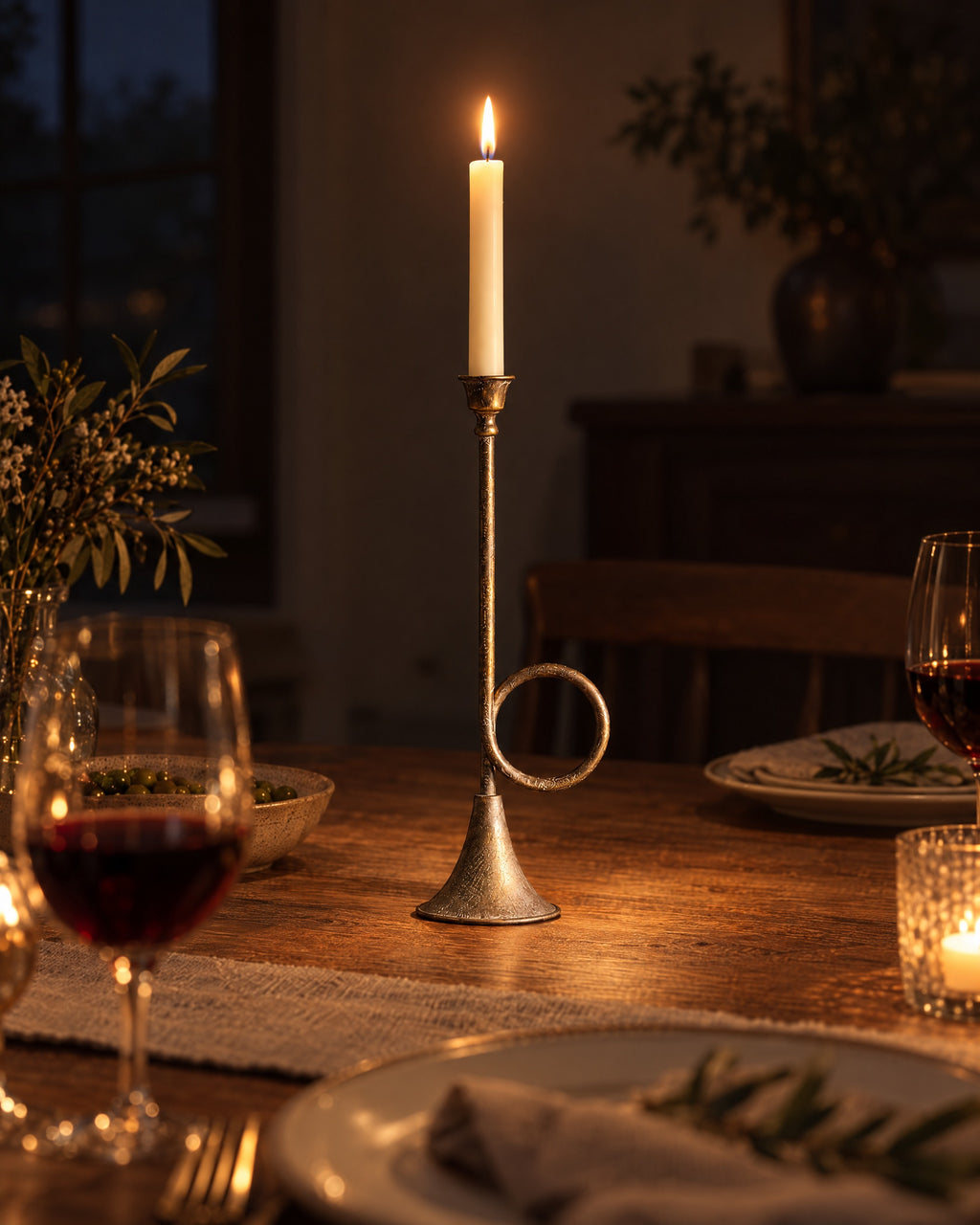 Tall (15.9 in): Corno Horn Ring Iron Candlestick with candles lit at night on a dinner table