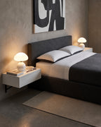 Pair of white Dolce mushroom lamps on floating nightstands on each side of a gray bed