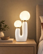 White: Duo Globe Sculptural Nightstand Lamp switched on on a nightstand in the evening