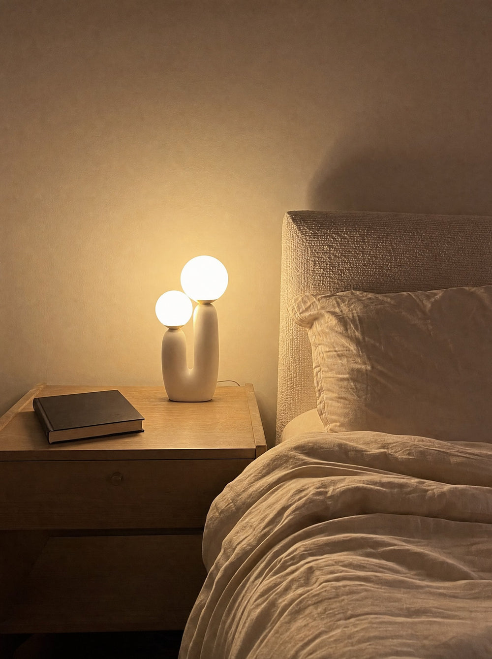 Duo Globe Sculptural Nightstand Lamp, at night on a nightstand