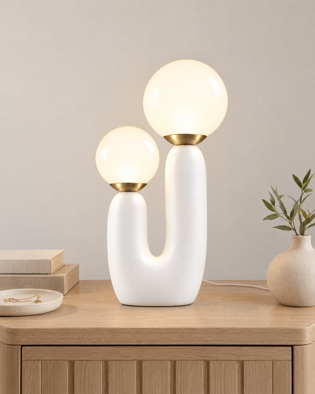 White: Duo Globe Sculptural Nightstand Lamp on a nightstand top against a light studio backdrop