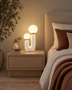 White: Duo Globe Sculptural Nightstand Lamp in a styled bedroom at dusk