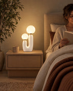 Duo Globe Sculptural Nightstand Lamp as a reading light beside a woman reading in bed