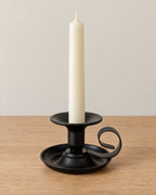 Tazza Iron Teacup Candle Holder on a light oak tabletop against a seamless studio backdrop