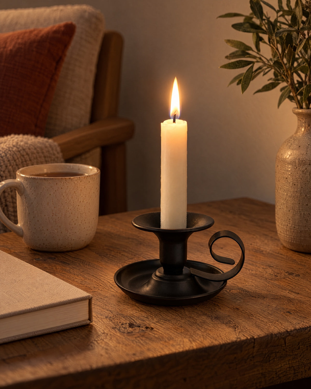 Tazza Iron Teacup Candle Holder, lit, in a lived-in evening scene
