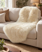 Cream: The Faux Sheepskin Rug, Cream, 2.8 in Fluffy Pile draped over a sofa