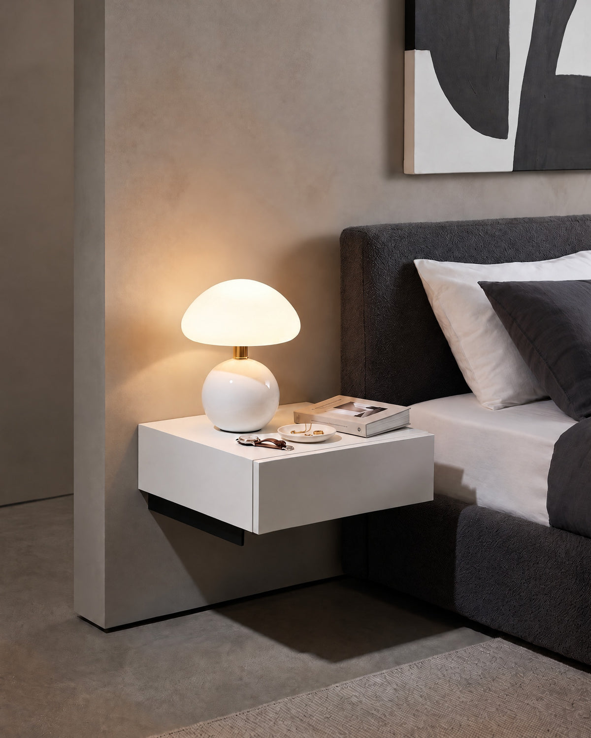 White Dolce mushroom nightstand lamp on a wall-mounted nightstand with a book and a trinket tray