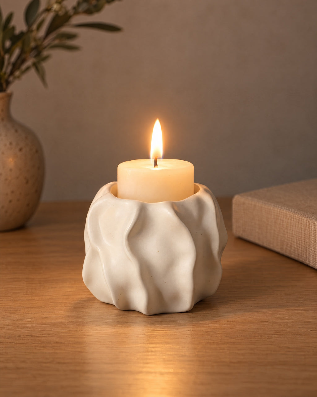 Low & Wide: Wave Abstract Ceramic Candle Holder, lit, on a styled surface in the evening
