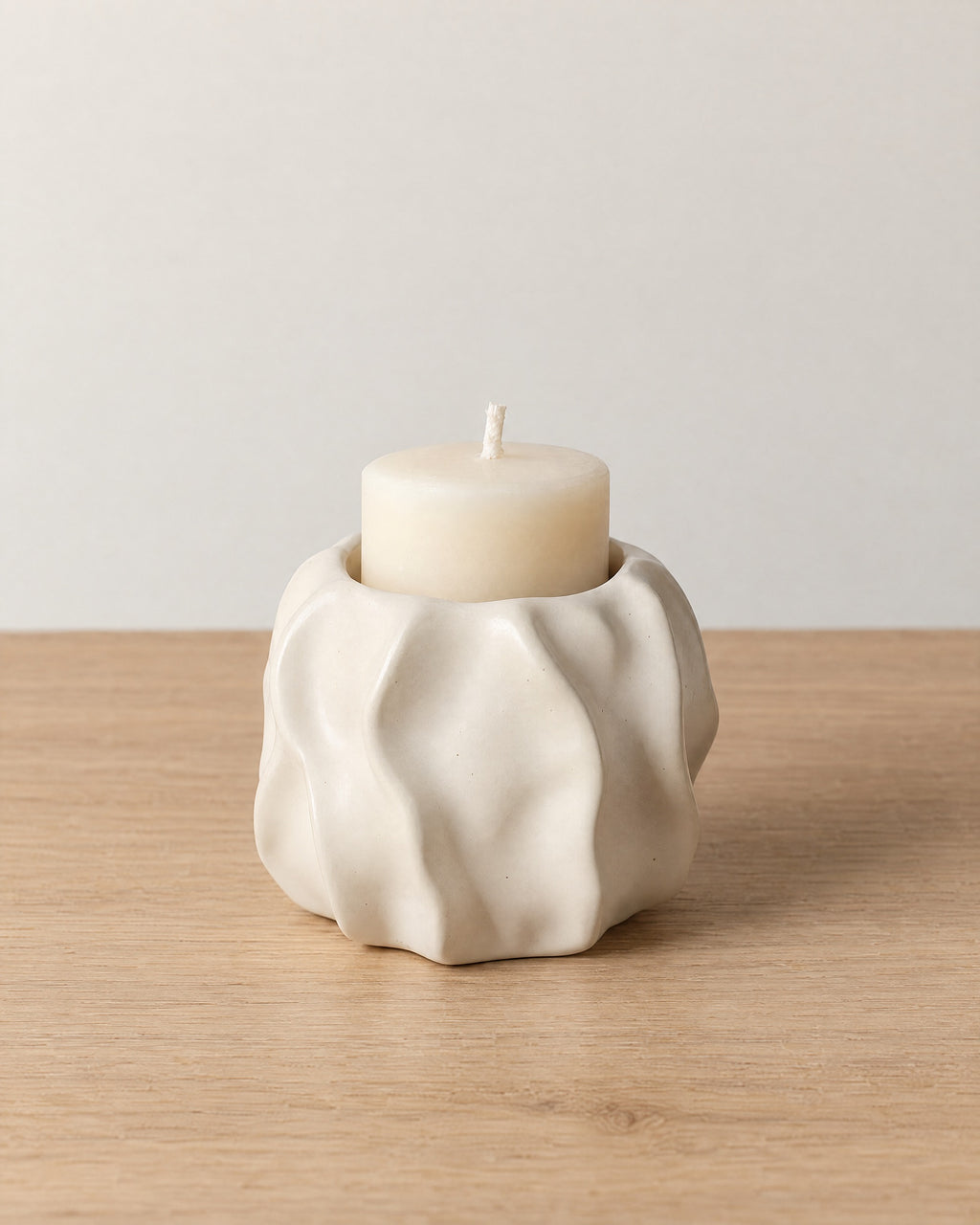 Low & Wide: Wave Abstract Ceramic Candle Holder on a light oak tabletop against a seamless studio backdrop