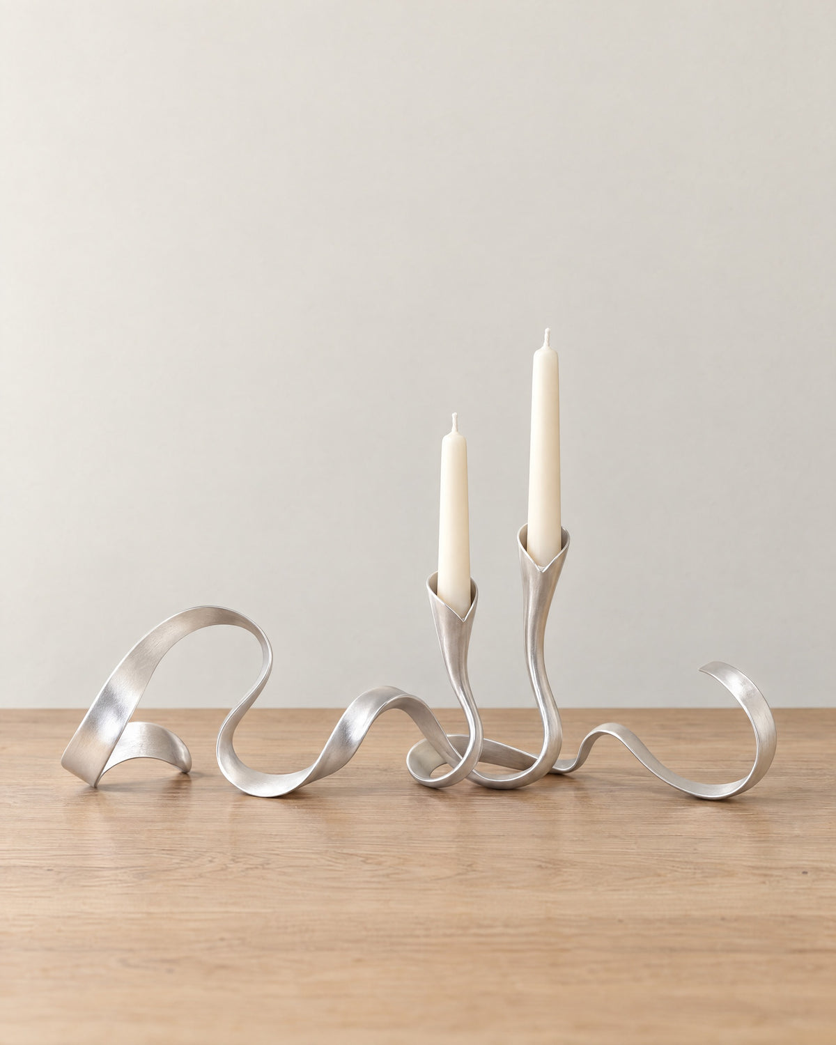 Silver: Ribbon Metal Candelabra on a light oak tabletop against a seamless studio backdrop