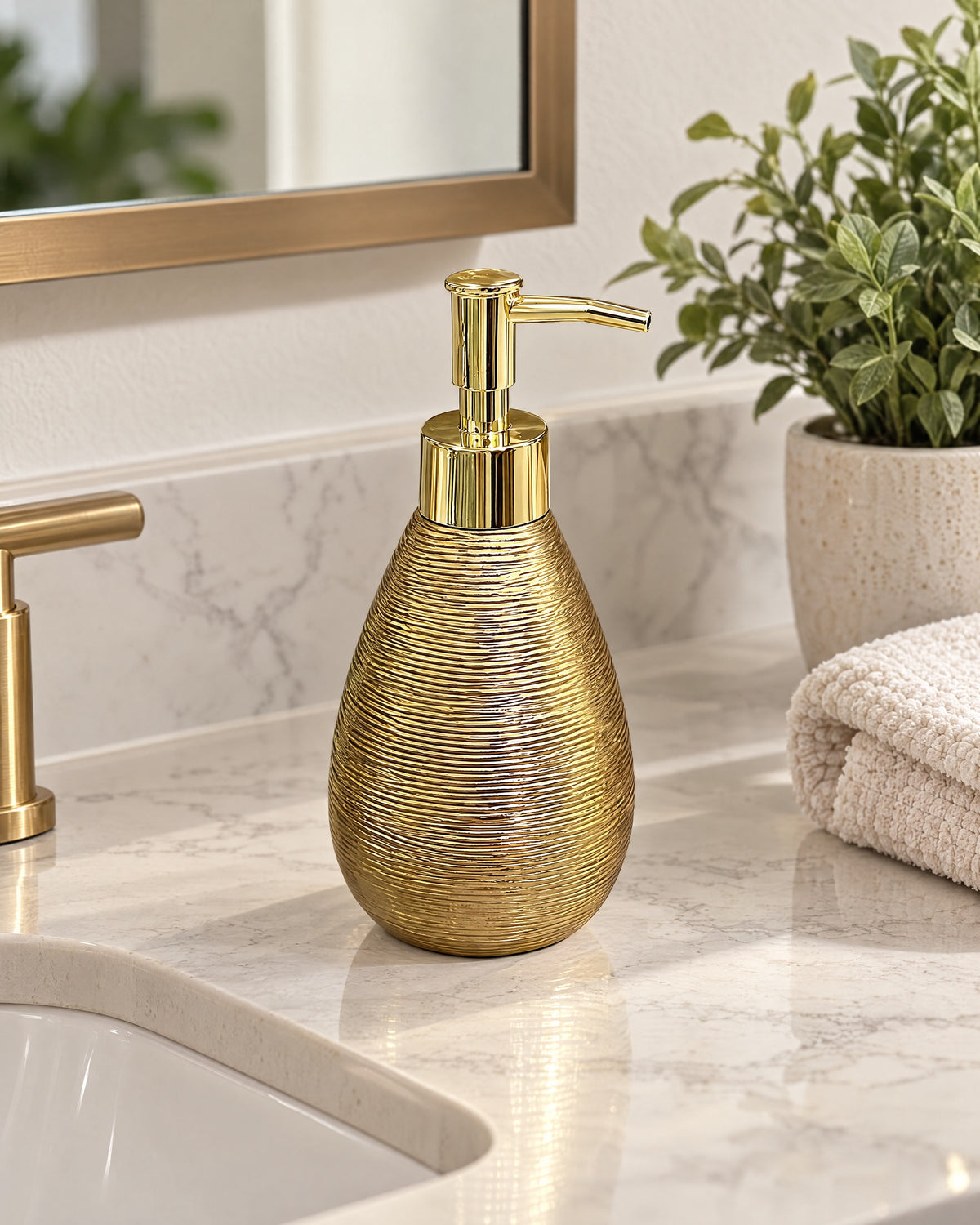 Teardrop Soap Dispenser, Ceramic, Brushed Gold styled on a bathroom counter