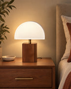 White Trim: Halvo Half Dome Walnut Nightstand Lamp in walnut / white trim lit on a nightstand in the evening