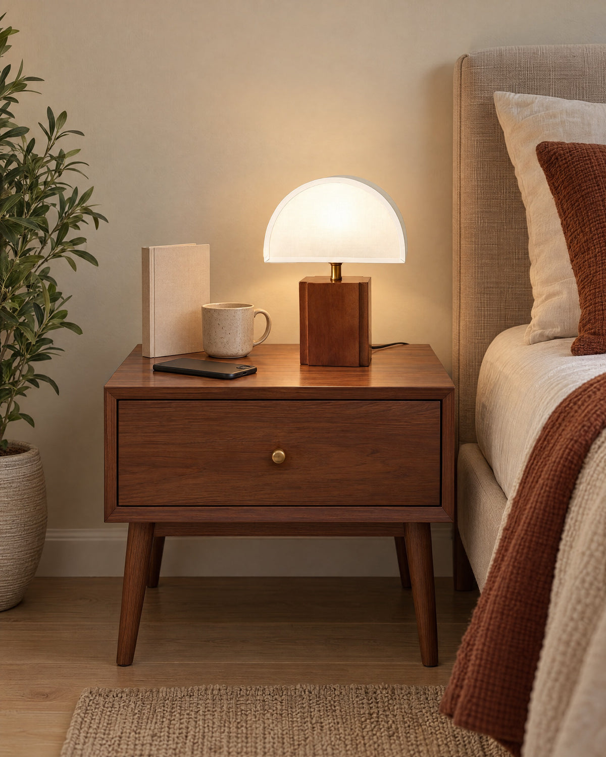 White Trim: Halvo Half Dome Walnut Nightstand Lamp in walnut / white trim on a standard nightstand with a book, phone and mug for scale