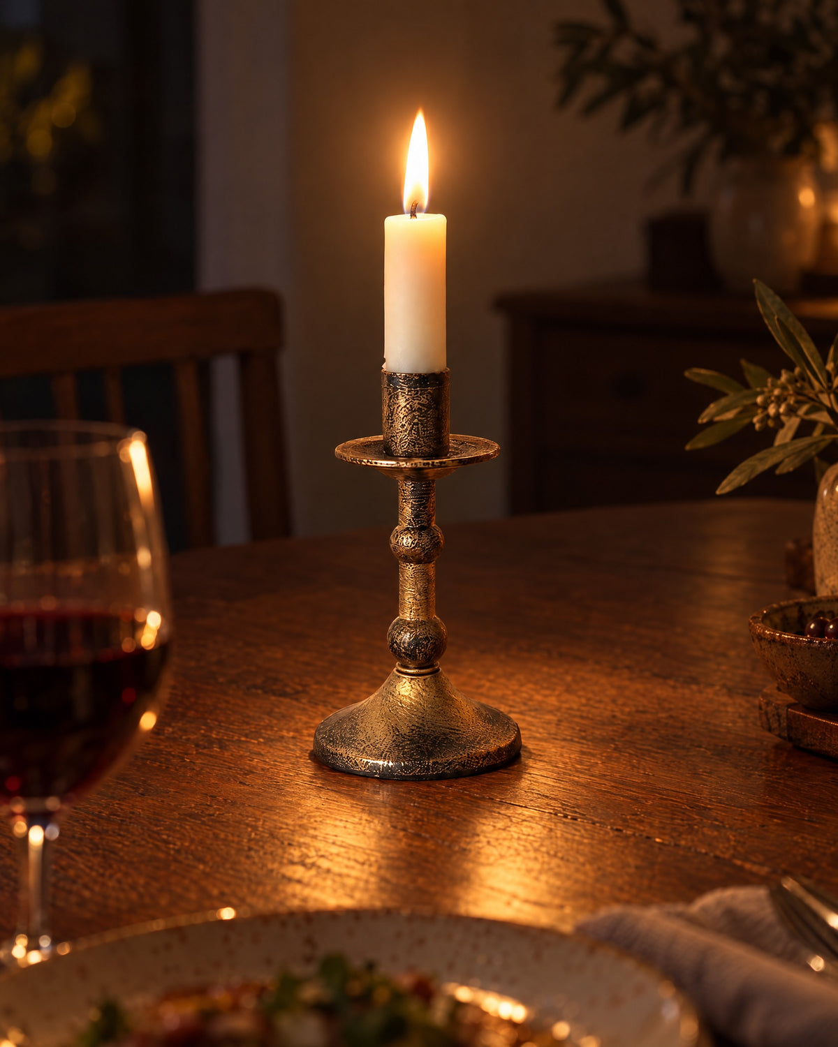 Heritage Distressed Metal Candlestick with candles lit at night on a dinner table