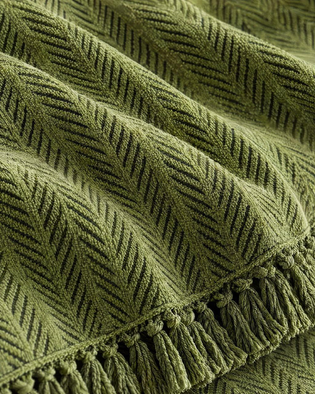 Green: Close-up of the fabric of the Herringbone Chenille Tassels Sofa Cover