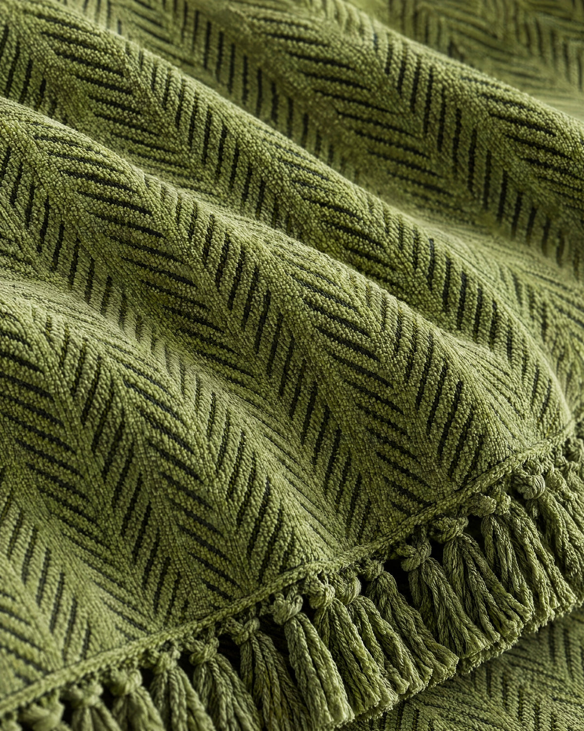 Green: Close-up of the fabric of the Herringbone Chenille Tassels Sofa Cover