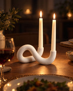 White: Knot Sculptural Double Candle Holder with candles lit at night on a dinner table