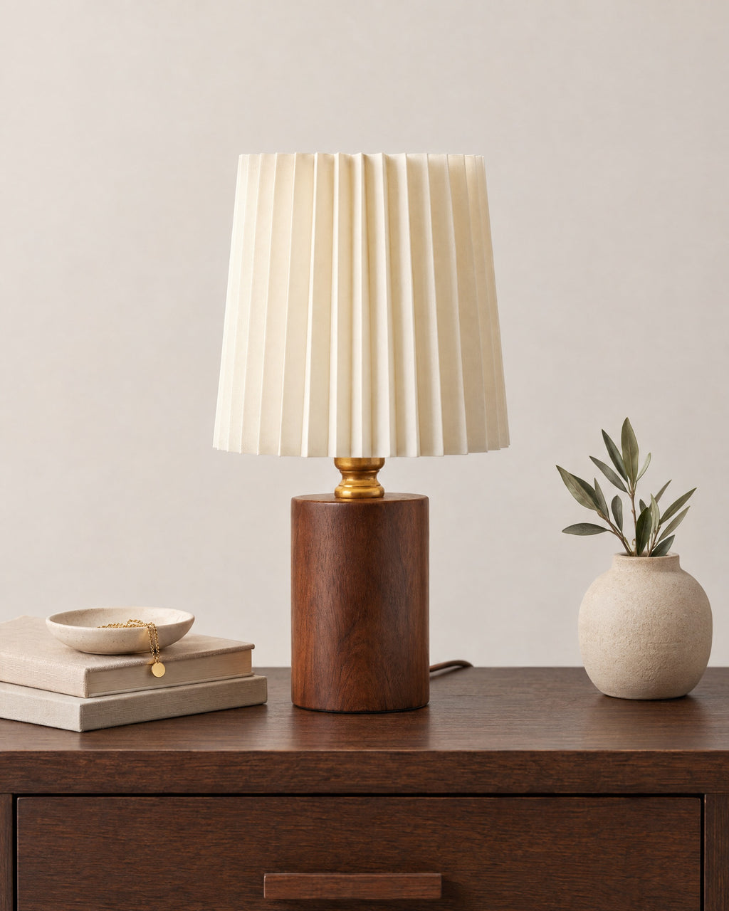Walnut: Linnea Pleated Wood Nightstand Lamp in walnut on a nightstand top against a plain backdrop