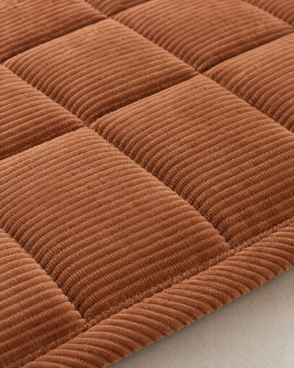 Chestnut Haze: Close-up of the fabric and edge of the Metro Line Quilted Couch Cover Mat