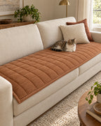 Chestnut Haze: A cat resting on the Metro Line Quilted Couch Cover Mat