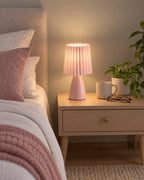 Pink: Milkshake Ceramic Cone Nightstand Lamp in a styled bedroom at dusk
