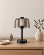 Black: Noir Cordless Dome Nightstand Lamp in black on a nightstand top against a light studio backdrop