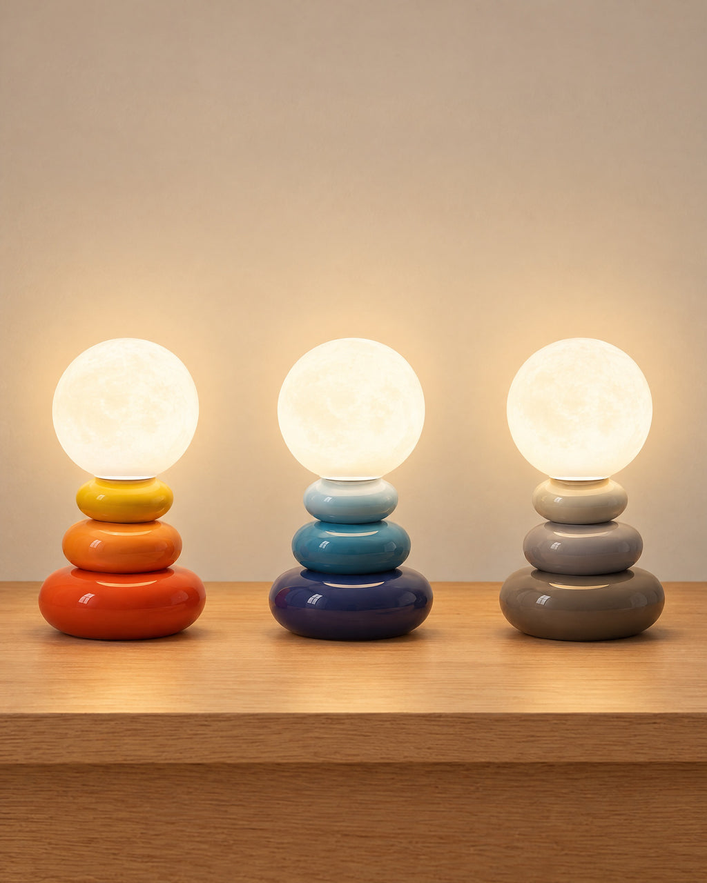 All colourways of the Pebble Stack Ceramic Nightstand Lamp side by side: Orange, Blue, Grey