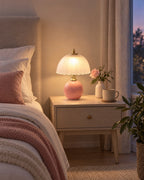 Pink: Petal Dome Ceramic Nightstand Lamp in pink in a styled bedroom at dusk