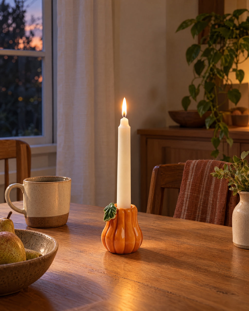 Zucca Pumpkin Ceramic Candle Holder styled in a warm interior at dusk
