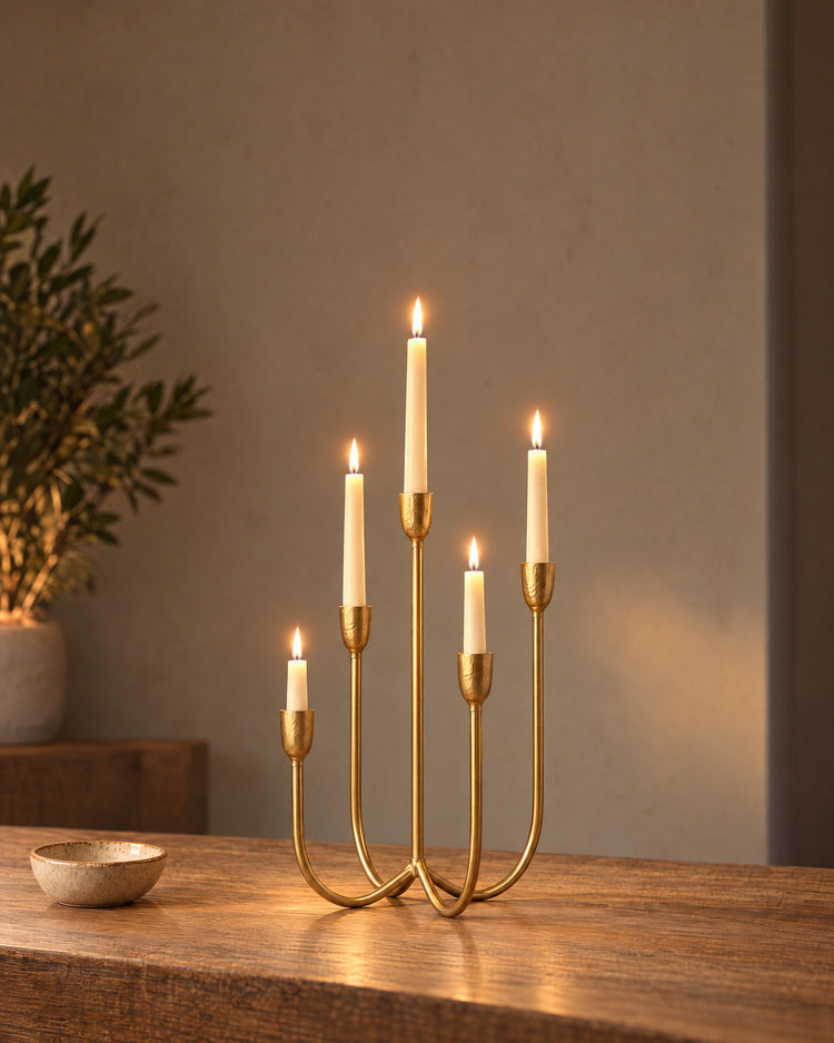 Quinta Five-Arm Iron Candelabra, lit, on a styled surface in the evening